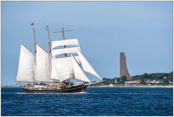 Die Gulden Leeuw mit vollen Segeln auf der Kieler Förde, im Hintergrund ist das Marine-Ehrenmal Laboe zu sehen.