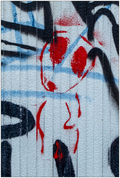 Ein Graffiti zeigt einen Alien auf einem grauen Verteilerkasten in Kiel.